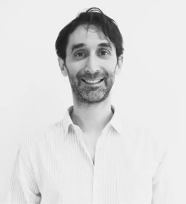 Ezequiel Grinberg parado, vestido elegante, en blanco y negro.