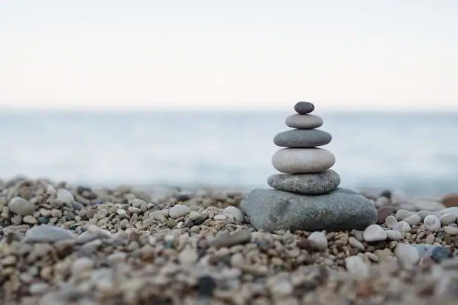Rocas apilidas una sobre otra, enfrente de un mar.